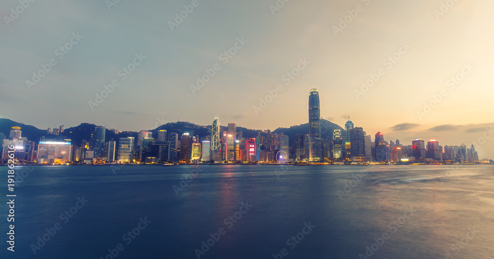 Fototapeta premium Malownicza panorama wyspy Hongkong z drapaczami chmur. Port Victoria o zachodzie słońca. Kolorowe tło podróży.