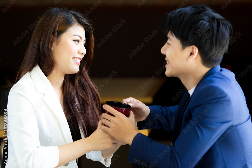 Asian couple aged between 25-30 years-old enjoy talking and drinking coffee together close up. Asian couple aged between 25-30 years-old enjoy talking and drinking coffee together close up.