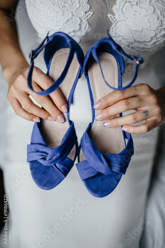 Bride holds the wedding shoes