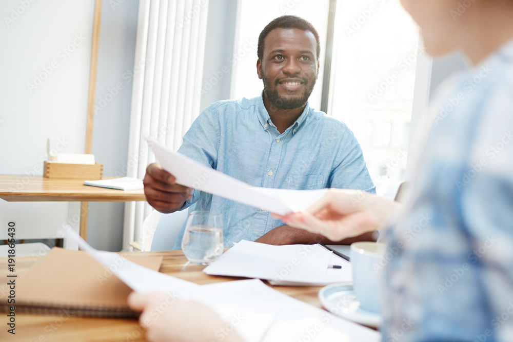 Businessman passing over paper or signed contract to his colleague or secretary Businessman passing over paper or signed contract to his colleague or secretary
