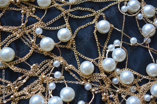 gold threads with pearls on black silk, beautiful luxury background