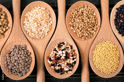 Variety of rice and grains in wooden spoons close up