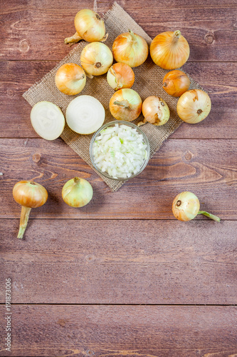 fresh onions on a wooden table background. wallpaper for grocery shopping and cooking food concept. top view, flat lay