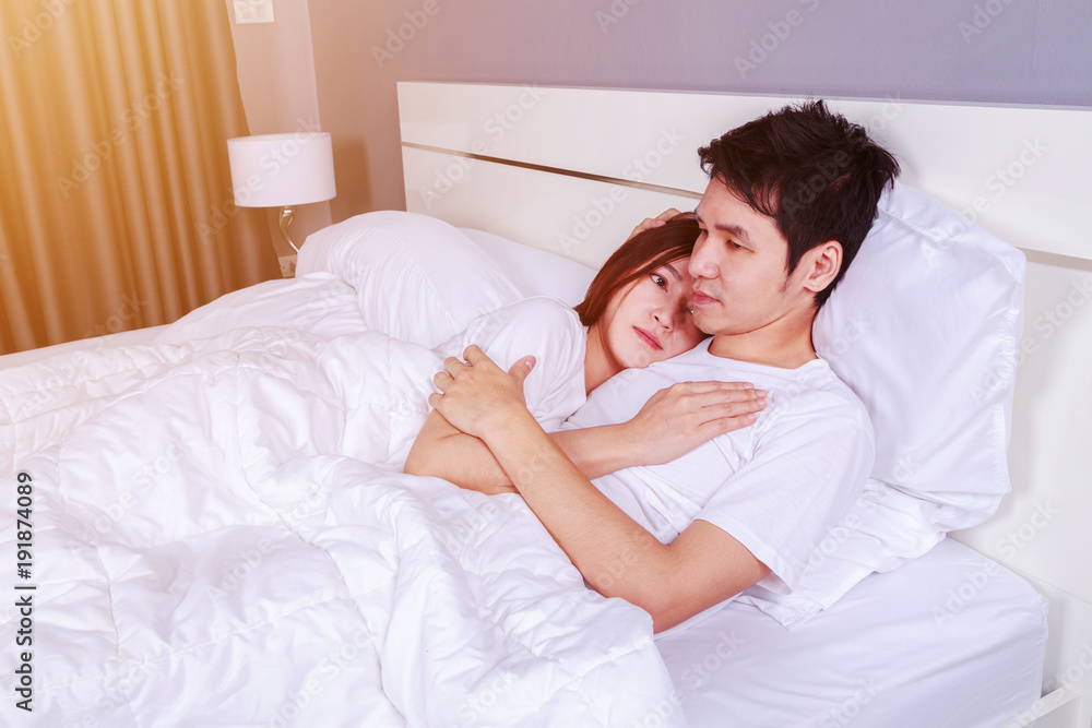 happy young attractive couple hugging on bed in bedroom happy young attractive couple hugging on bed in bedroom