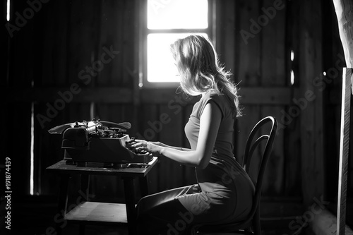 A girl prints on an old typewriter