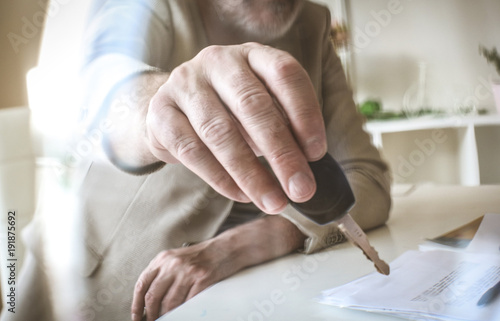 Mature businessman gives a car key to client. Close up. © liderina