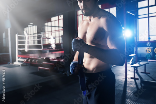 Boxer applying hand wraps w...