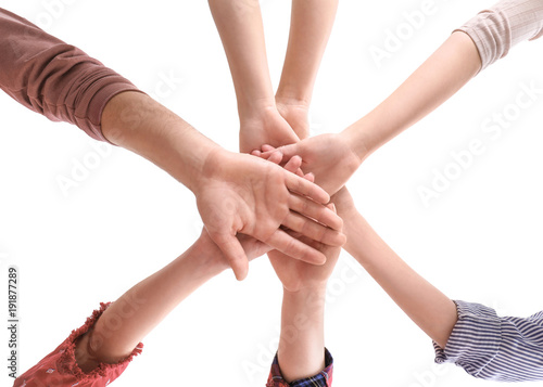 Young people putting hands together as symbol of unity, on white background © Africa Studio