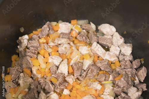 turkey meat is cooked in a pan. Beef, onion, carrot