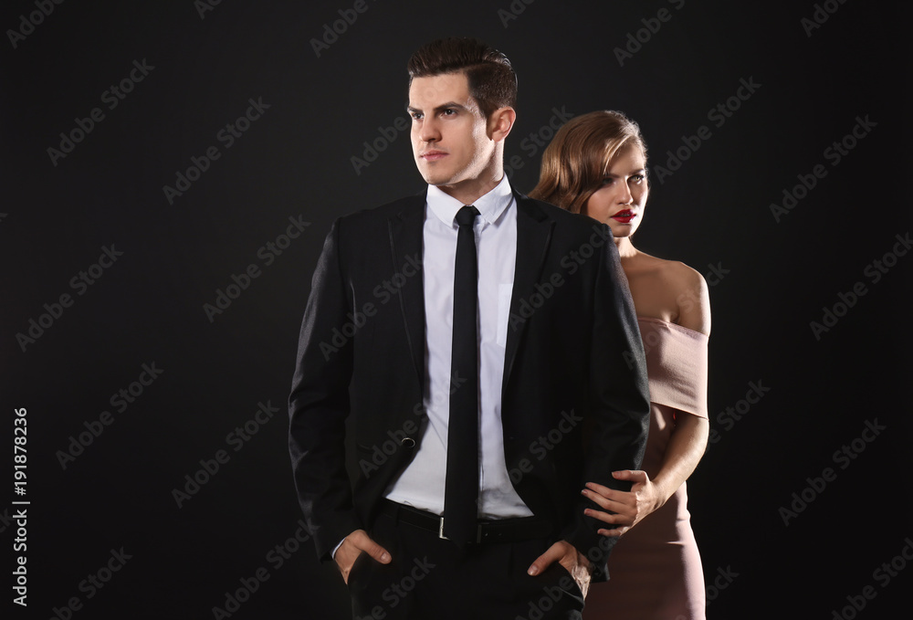 Sexy woman and businessman in suit on dark background Sexy woman and businessman in suit on dark background
