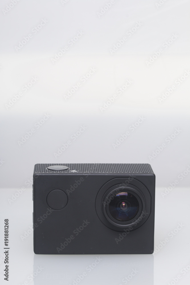 The action camera lies on a white surface. The action camera lies on a white surface.