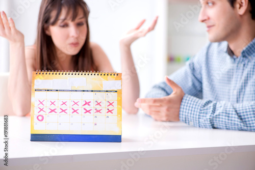 Young family in pregnancy planning concept with ovulation calend photo
