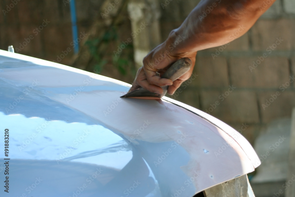 Automotive paint technician using paint on putty knife at , A