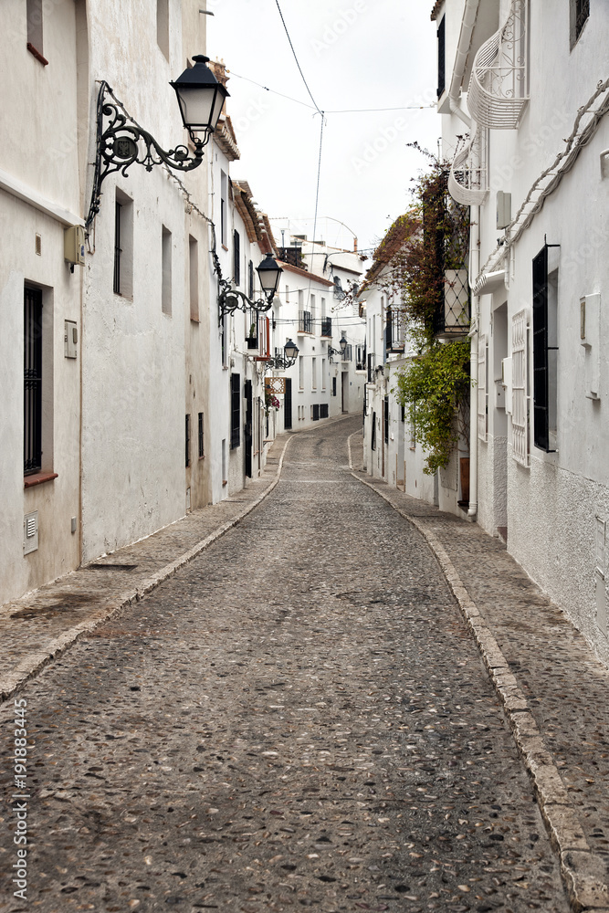 Fototapeta premium One of the streets of the beautiful old town Altea, located in the Costa Blanca of Spain. White houses with flowers