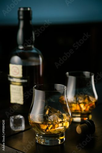Canvas Print Whiskey in glasses with ice on rustic background