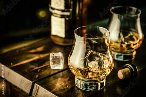 Canvas Print Whiskey in glasses with ice on rustic background