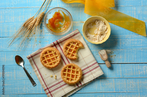 small pies with ingredients around on light blue table