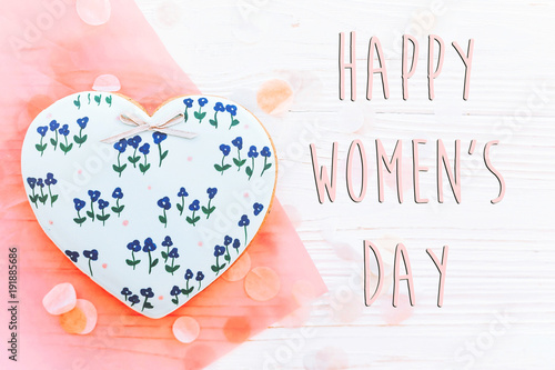 happy women's day text sign flat lay. 8 march. pink hearts  flowers and confetti on white rustic wooden background. space for text. greeting card concept. womens bright image