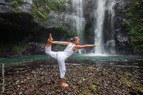 Woman practices yoga near Sekumpul waterfall in Bali  Indonesia