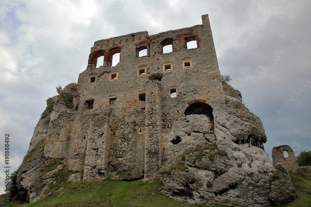 Ruins of medieval castle in Ogrodzieniec, Poland, against cloudy skay, view from down