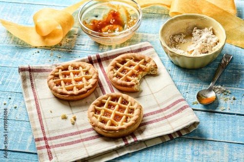 small pies with ingredients around on light blue table
