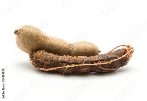 Two Indian dates tamarind one without shell isolated on white background brown jelly flesh. photo