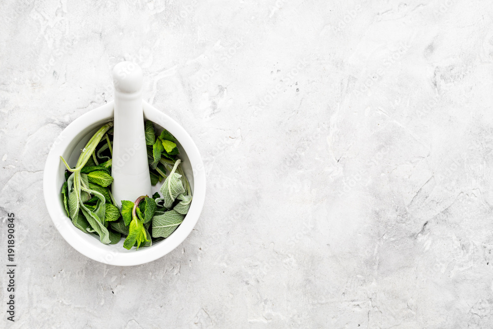 Phytotherapy. Herbs in mortar bowl on white background top view copy space Phytotherapy. Herbs in mortar bowl on white background top view copy space