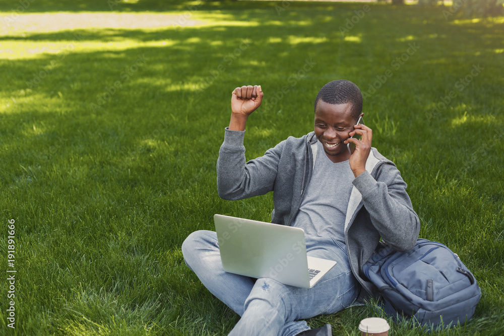 Happy successful african-american student with arm raised in the air Happy successful african-american student with arm raised in the air