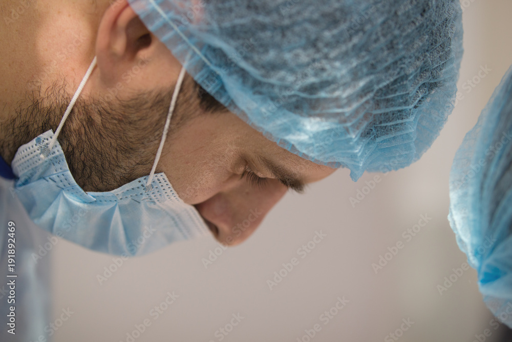 Doctor surgeon looking at a patient in operating theater