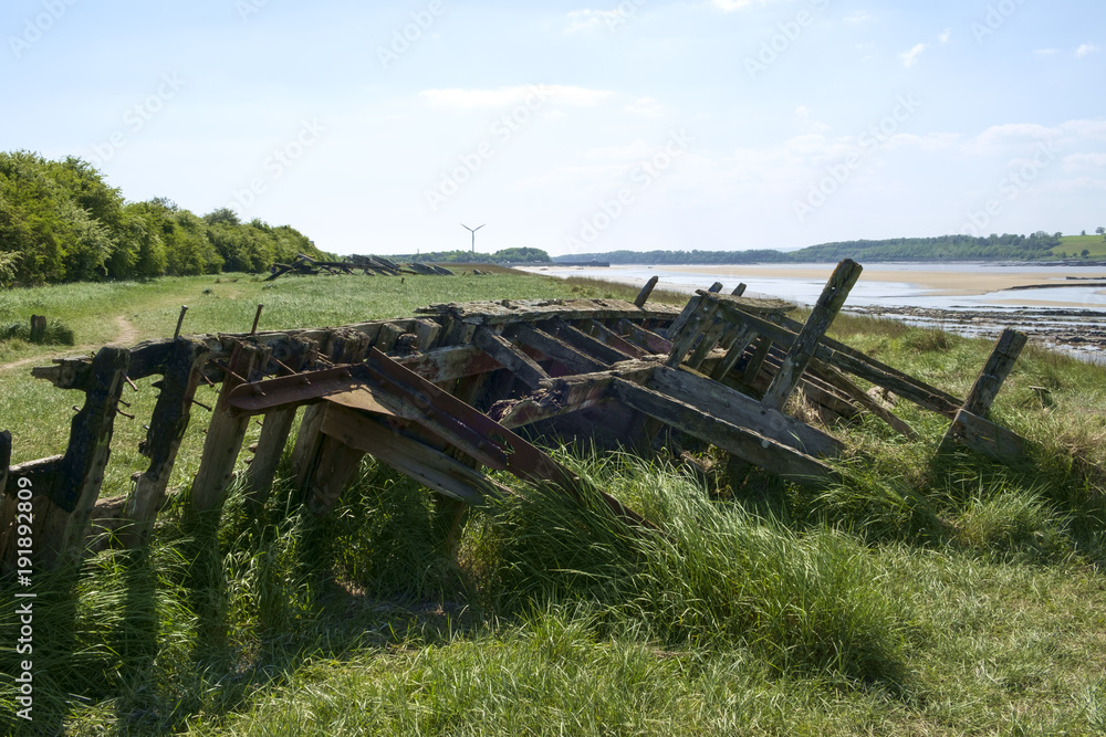 Obsolete small boats and barges were stranded on the banks of the tidal River Severn in Gloucestershire, UK to protect the river banks from erosion.