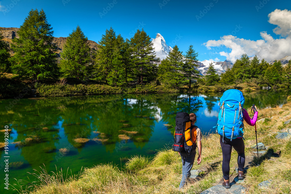 Hikers with mountain equipment near Grindjisee lake, Zermatt, Switzerland, Europe