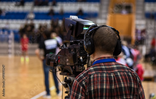 video operator recording a sports match on a professional video camera