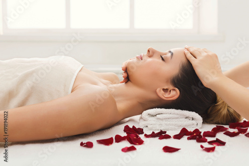 Woman getting professional facial massage at beauty salon