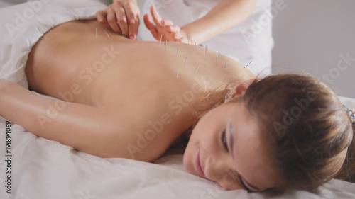 Young female relaxing in spa salon - oil sesame massage