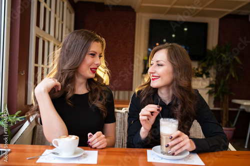 Two beautiful girls drinking coffee