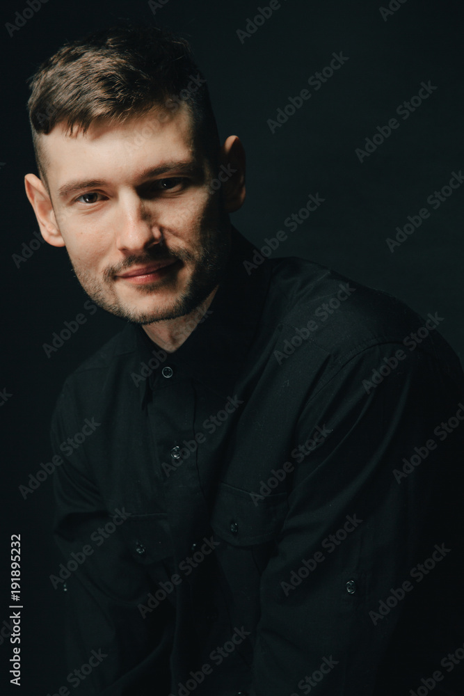 Obraz premium Man in headphones and black shirt on a black background