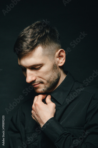 Man in headphones and black shirt on a black background