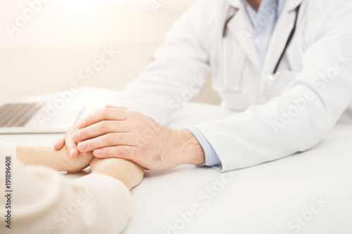 Closeup of patient and doctor hands