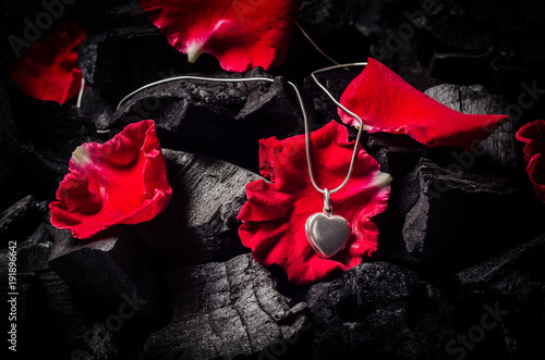 Silver heart  shape locket with necklace on black charcoal texture background