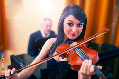 Portrait of a smiling woman playing her violin