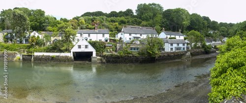 Picturesque old cottages line the waters edge in Helford village on the Helford Estuary in Cornwall, UK