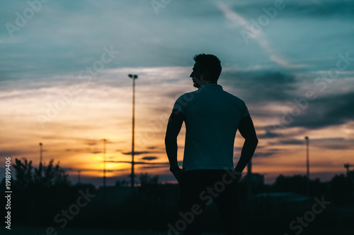 Silhouette of a young man in the sunset background