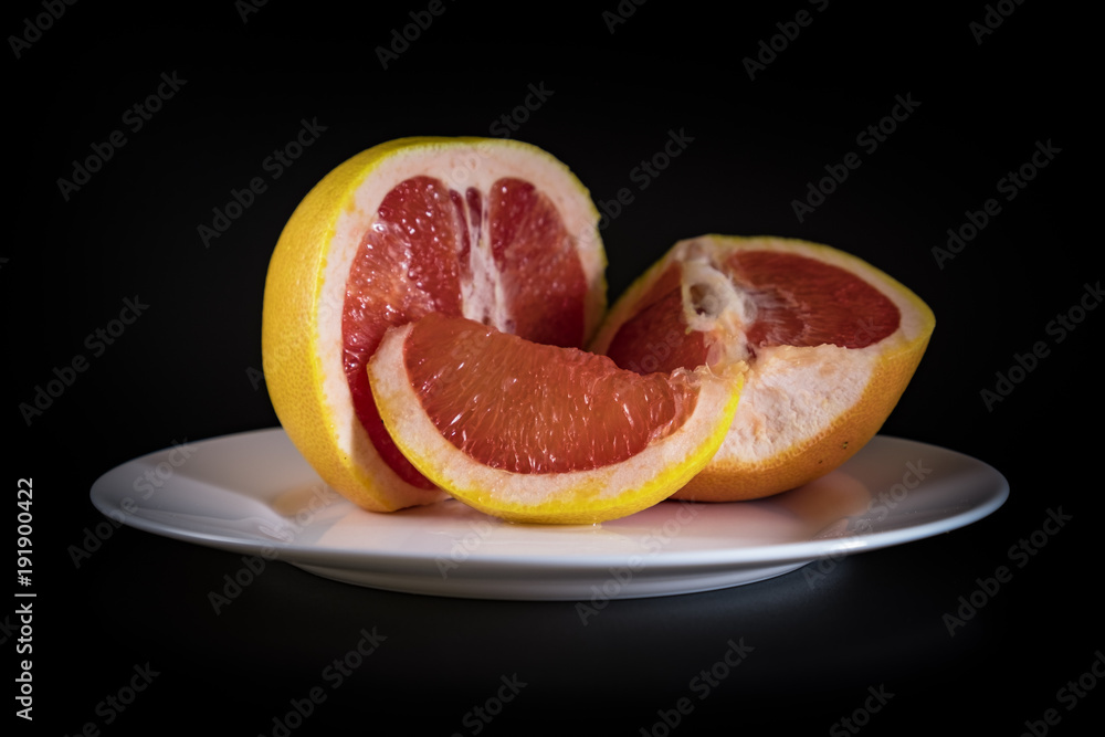 Mature grapefruit on a white plate close-up Mature grapefruit on a white plate close-up