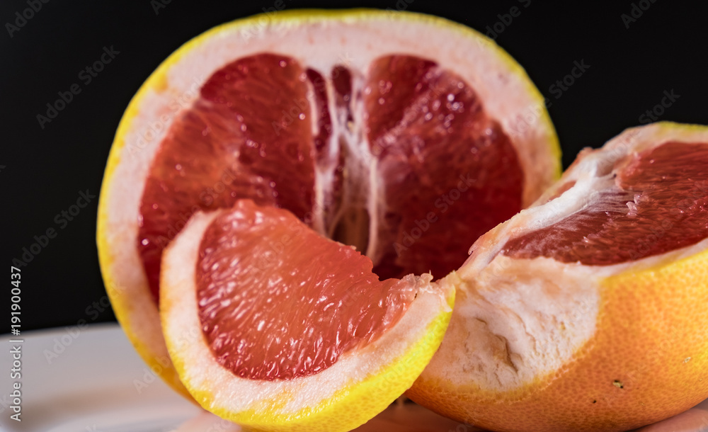 Mature grapefruit on a white plate close-up Mature grapefruit on a white plate close-up