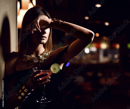 Beautiful sexy fashion brunette woman in expensive interior restaurant relaxing with martini cosmopolitan cocktail 