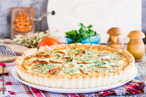 Homemade french quiche pie with tomato, cheese and herb on a plate