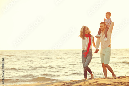 portrait of happy family and baby enjoying sunset in the summer leisure