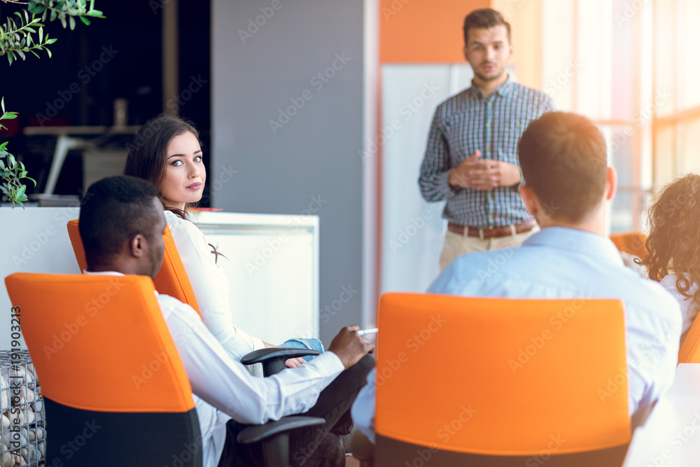 Obraz premium Group of casually dressed businesspeople discussing ideas in the office.