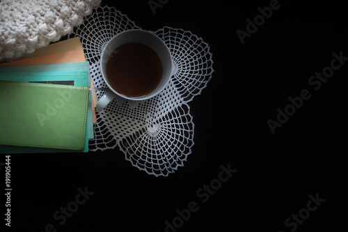 filiżanka herbaty, książki na czarnym tle