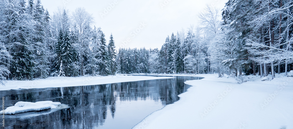 Naklejka premium Sunrise river in a cold winter landscape with snow and frost